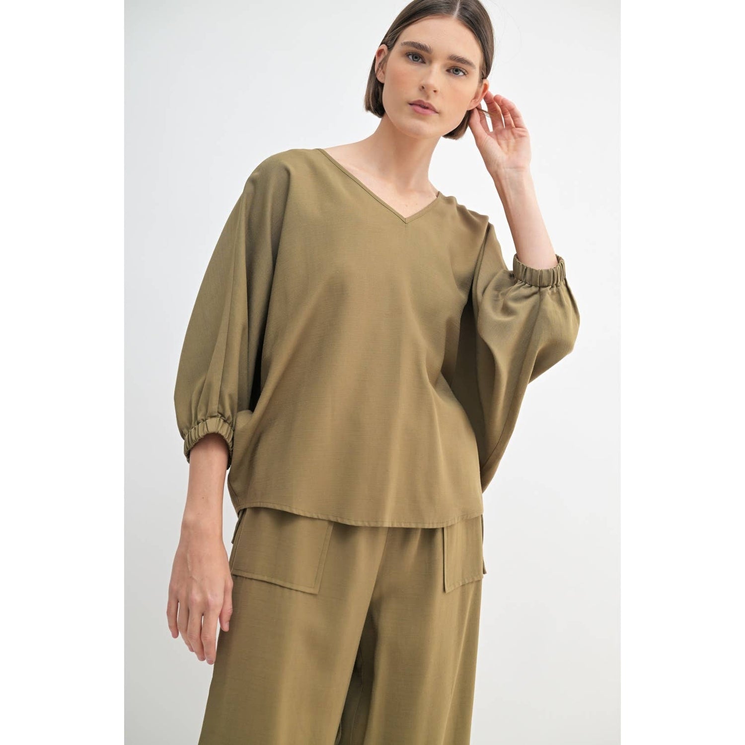 Olive Oversized Dolman V-Neck Top showcasing elasticised cuff sleeves