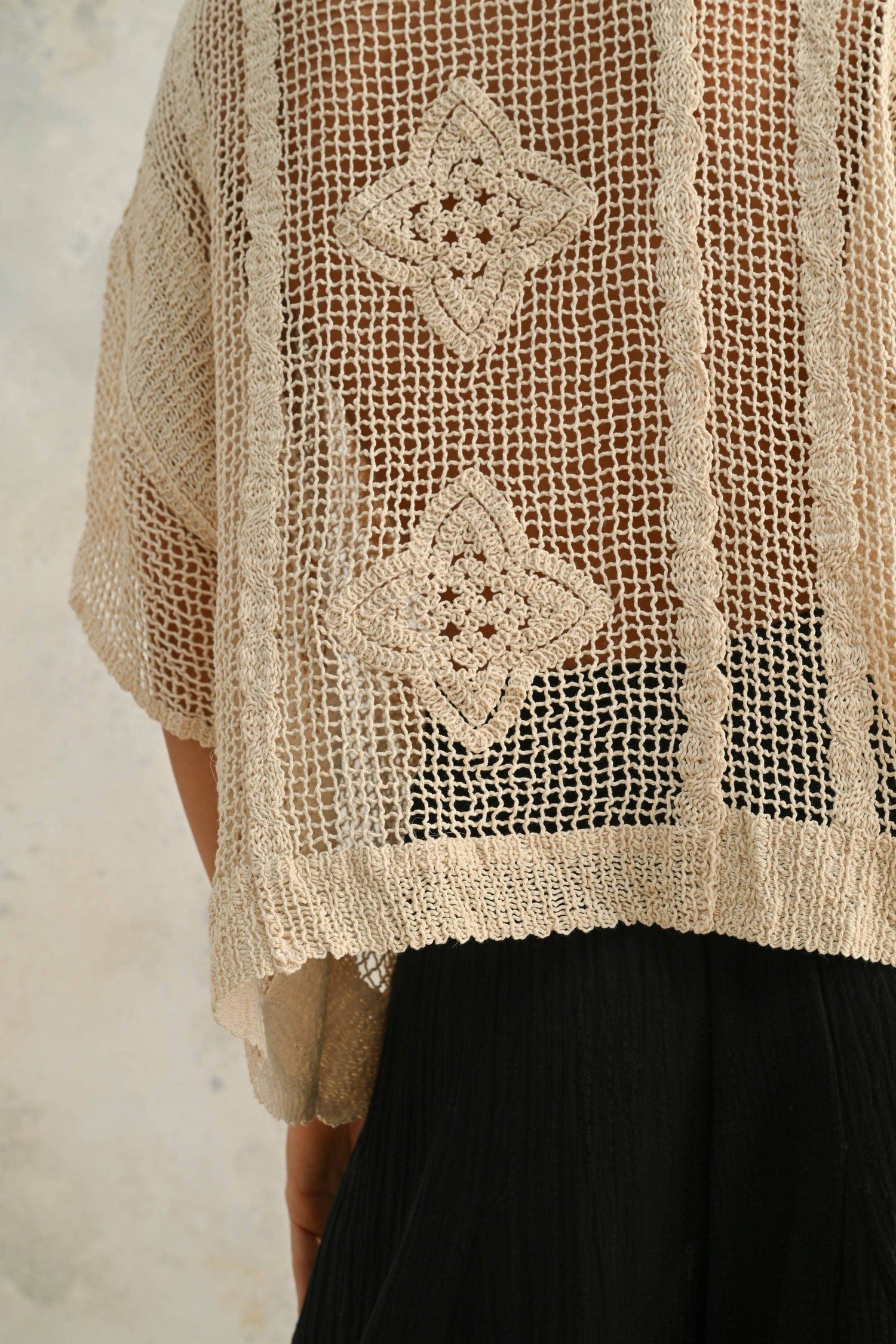 Back close-up highlighting the open crochet pattern and lightweight, breathable detail.