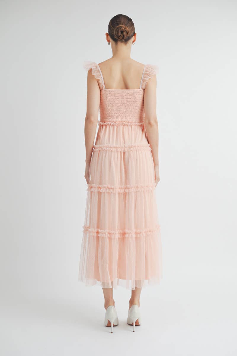 Back view of Clovette Midi Dress in blush pink with smocked back and tiered skirt