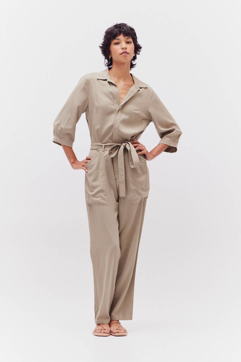 Woman wearing a beige jumpsuit on a white background