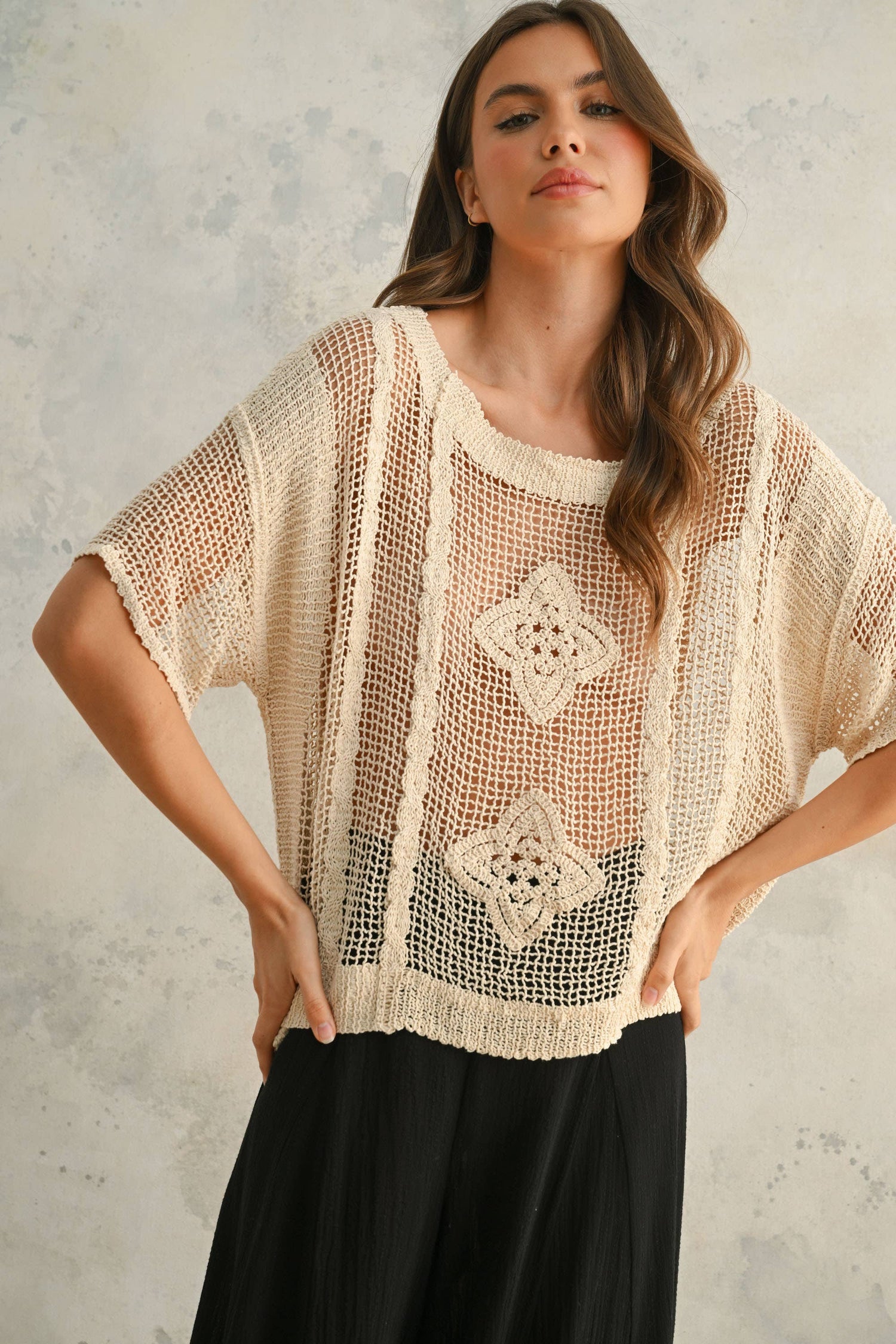 Front close-up of the beige crochet top showing the intricate knit texture and feminine neckline.