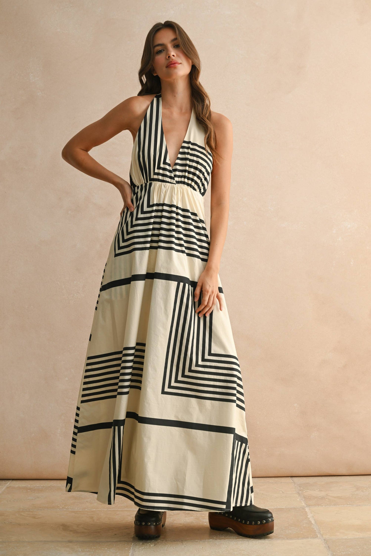 Front view of the geometric multi‑print halter dress showing the bold pattern and clean neckline.